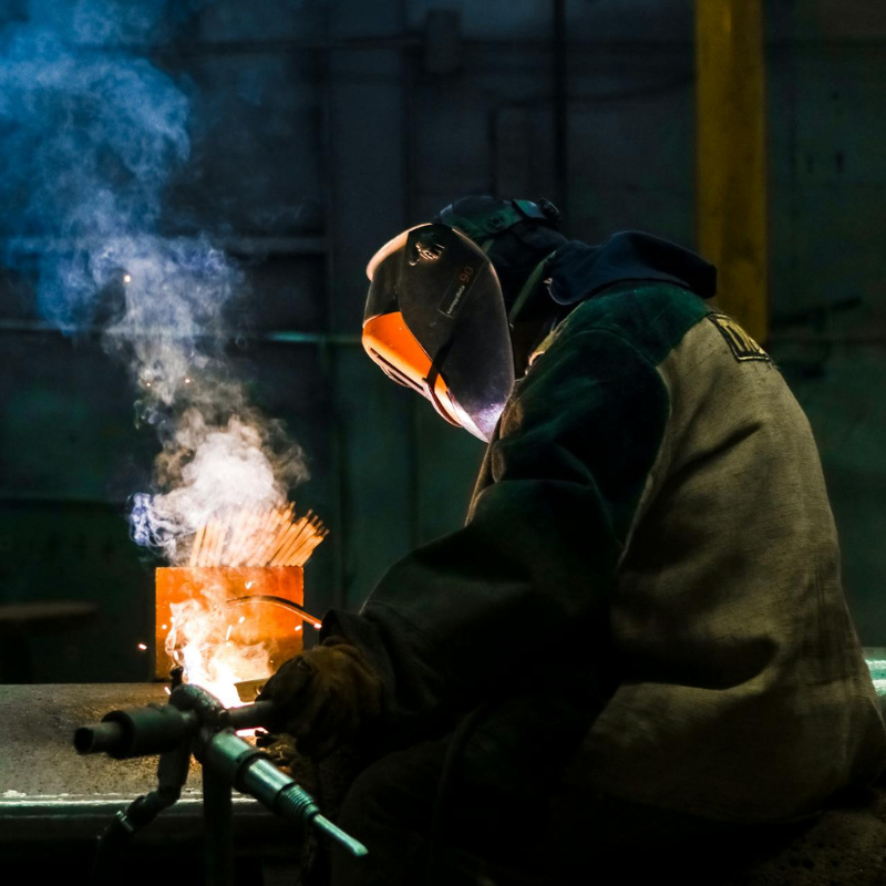 a welder in the middle of performing a stud weld 